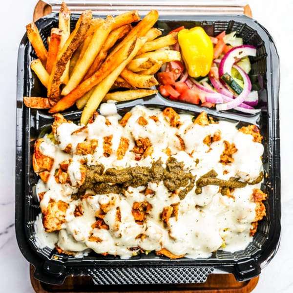 Zalim Hot Chicken & Burgers' chicken over rice with fries and salad in a black to-go container.